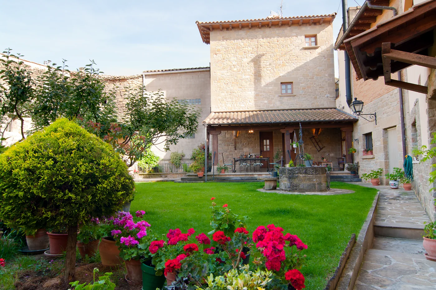 Fachada de piedra, porche y jardín de Casa Rural El Pajar